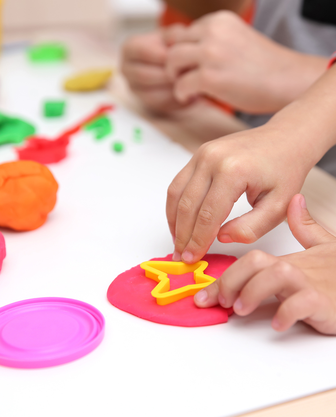 Little children engaged in playdough modeling at daycare, closeu